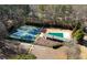 Aerial view of a tennis court and a covered swimming pool with mature trees in a fenced yard at 240 Pinebrook Way, Roswell, GA 30076