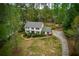 Aerial view of a two-story home with a well-kept lawn, mature trees, and a long driveway at 240 Pinebrook Way, Roswell, GA 30076