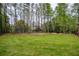 Spacious backyard featuring lush lawn and beautiful trees, ideal for outdoor activities at 240 Pinebrook Way, Roswell, GA 30076