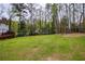 Lush backyard featuring a large grassy area bordered by mature trees, providing a private outdoor space at 240 Pinebrook Way, Roswell, GA 30076