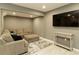 A fully finished basement area with a comfy sectional sofa, flat screen television, table, ottoman and a grey rug at 240 Pinebrook Way, Roswell, GA 30076
