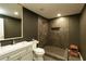 Modern bathroom featuring a tiled walk-in shower, a vanity with a sink, and dark neutral walls at 240 Pinebrook Way, Roswell, GA 30076