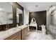 Stylish bathroom features double vanity, marble floors, toilet, makeup table, and glass enclosed shower at 240 Pinebrook Way, Roswell, GA 30076