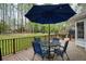 Outdoor wooden deck with table, chairs, and umbrella overlooking the green backyard at 240 Pinebrook Way, Roswell, GA 30076