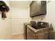 Modern laundry room featuring a front load washer and dryer with upper cabinets at 240 Pinebrook Way, Roswell, GA 30076