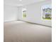 Bright bedroom featuring neutral carpet, white walls, and two windows that provide natural light at 8227 Coldstream Dr, Fairburn, GA 30213