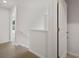 Upstairs hallway with an open view to other rooms, carpeted floor, and a window view at 8227 Coldstream Dr, Fairburn, GA 30213