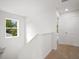 An upstairs hallway with bright natural light from a window and leading to bedrooms at 8227 Coldstream Dr, Fairburn, GA 30213