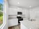 Modern kitchen with white cabinets, stainless steel appliances, granite countertops, and abundant natural light at 8227 Coldstream Dr, Fairburn, GA 30213