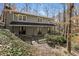 View of the back of home with deck, siding, double doors and wooded backyard at 7127 Riverside Dr, Atlanta, GA 30328