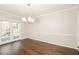 Dining room with wood flooring, a modern chandelier, and access to the outdoor deck at 7127 Riverside Dr, Atlanta, GA 30328