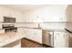 Well-lit kitchen with stainless steel appliances, white cabinets, granite countertops, and dark wood flooring at 7127 Riverside Dr, Atlanta, GA 30328