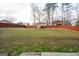 A large, fenced backyard with a mix of grass and natural areas provides privacy and space at 5143 Olive Branch Cir, Powder Springs, GA 30127