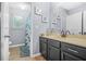 Clean bathroom featuring gray vanity with sink, framed art, and shower with blue curtain at 5143 Olive Branch Cir, Powder Springs, GA 30127