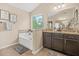 Bathroom featuring a soaking tub with a ledge and window, granite countertops, and wooden cabinets at 5143 Olive Branch Cir, Powder Springs, GA 30127