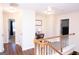 View of the upstairs hallway with hardwood floors and a decorative round table with framed art at 5143 Olive Branch Cir, Powder Springs, GA 30127