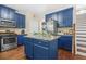 Kitchen featuring dark blue cabinets, an island with a granite countertop and stainless steel appliances at 5143 Olive Branch Cir, Powder Springs, GA 30127