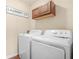 Functional laundry room with washer, dryer, and overhead cabinet at 5143 Olive Branch Cir, Powder Springs, GA 30127