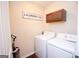 Practical laundry room featuring a modern washer, dryer, upper cabinets and decor at 5143 Olive Branch Cir, Powder Springs, GA 30127