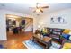 Open-concept living area with kitchen view, hardwood floors, and a comfortable seating area with a fan at 5143 Olive Branch Cir, Powder Springs, GA 30127