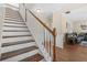 Staircase with white risers, wood treads and a view of the living room at 5143 Olive Branch Cir, Powder Springs, GA 30127