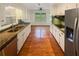 Galley kitchen with granite counters, stainless steel appliances, and hardwood floors at 724 Dukehart Ct, Stone Mountain, GA 30083