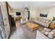 Bright living room is virtually staged with neutral furniture and a brick fireplace at 724 Dukehart Ct, Stone Mountain, GA 30083