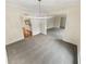 Well-lit living room featuring light gray carpet, a modern light fixture, and adjoining rooms at 724 Dukehart Ct, Stone Mountain, GA 30083