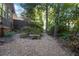 Secluded backyard featuring a stone bench, a gravel pathway, and lush greenery, creating a peaceful retreat at 90 W Peachtree St, Norcross, GA 30071