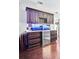 Home bar featuring dark cabinetry, marble countertop, and a beverage fridge at 90 W Peachtree St, Norcross, GA 30071