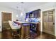 Home bar featuring dark cabinetry, marble countertop, lighting, and seating at 90 W Peachtree St, Norcross, GA 30071