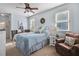 Cozy bedroom features a plush bed with pillows, carpet, a ceiling fan and natural light at 90 W Peachtree St, Norcross, GA 30071