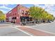Paizanos Gallery building exterior featuring red brick facade and black awnings on a sunny day at 90 W Peachtree St, Norcross, GA 30071