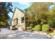 Charming home featuring a spacious driveway, two-car garage, and a small balcony surrounded by lush landscaping at 90 W Peachtree St, Norcross, GA 30071