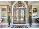 Elegant front door with glass panels, flanked by potted trees and decorative lanterns at 90 W Peachtree St, Norcross, GA 30071