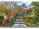 Charming home featuring a stone stairway, manicured landscaping, and covered porch perfect for relaxing at 90 W Peachtree St, Norcross, GA 30071