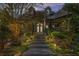 Evening shot of a charming home with stone stairway, manicured landscaping, and illuminated exterior lights at 90 W Peachtree St, Norcross, GA 30071