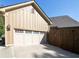 A well-lit, two-car garage featuring a paneled door and classic exterior lighting, with adjacent backyard access at 90 W Peachtree St, Norcross, GA 30071