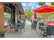 Outdoor cafe seating area with tables, chairs, umbrellas and a 'drink specials' sign at 90 W Peachtree St, Norcross, GA 30071