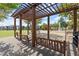 Swings hang under a wooden arbor in a park with a splash pad and apartment buildings nearby at 90 W Peachtree St, Norcross, GA 30071