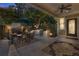 Night view of a patio with a fireplace, outdoor kitchen, and dining set at 90 W Peachtree St, Norcross, GA 30071