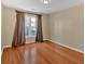 Sunny bedroom featuring a window with dark drapes and wood flooring at 2445 Ridgelake Dr, Villa Rica, GA 30180