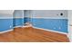 Spacious bedroom featuring hardwood floors, two-tone walls, and a partial view of the staircase at 2445 Ridgelake Dr, Villa Rica, GA 30180