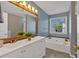 A bathroom featuring a double sink vanity, large mirror, and a separate soaking tub with jets at 4342 Richmond Nw Pl, Acworth, GA 30101