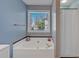 A soaking tub next to a shower and window with blind coverings in the bathroom at 4342 Richmond Nw Pl, Acworth, GA 30101
