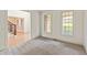 Sunlit bedroom featuring soft carpet, large windows, and an open view to the home's staircase at 500 Poplar Creek Xing, Canton, GA 30114