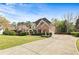 View of a two-story home showcasing a long driveway leading to a spacious two-car garage at 500 Poplar Creek Xing, Canton, GA 30114