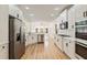 Well-lit kitchen with white cabinets, marble countertops, stainless steel appliances, and wood floors at 500 Poplar Creek Xing, Canton, GA 30114