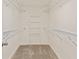 Spacious walk-in closet featuring white walls, carpeted floor and ample shelving units for convenient storage at 500 Poplar Creek Xing, Canton, GA 30114