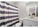 Bathroom featuring a shower with a blue and white striped shower curtain, white toilet and vanity at 234 Retreat Ln, Canton, GA 30114